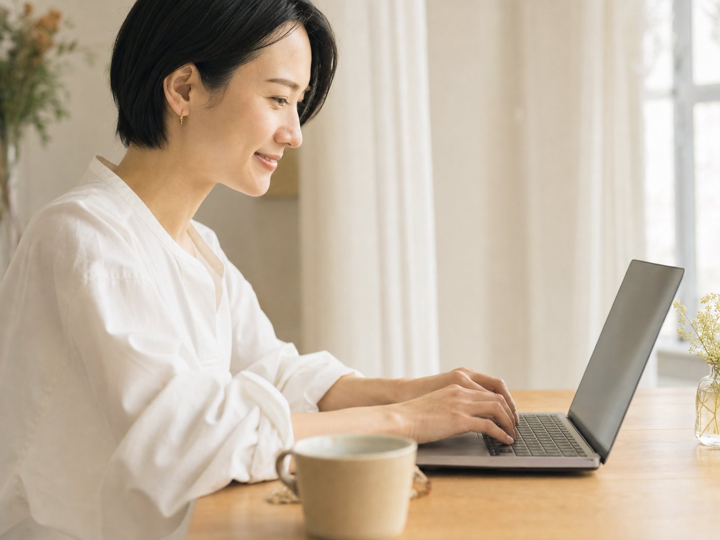 窓際でノートPCに向かい、作りながら学ぶ女性